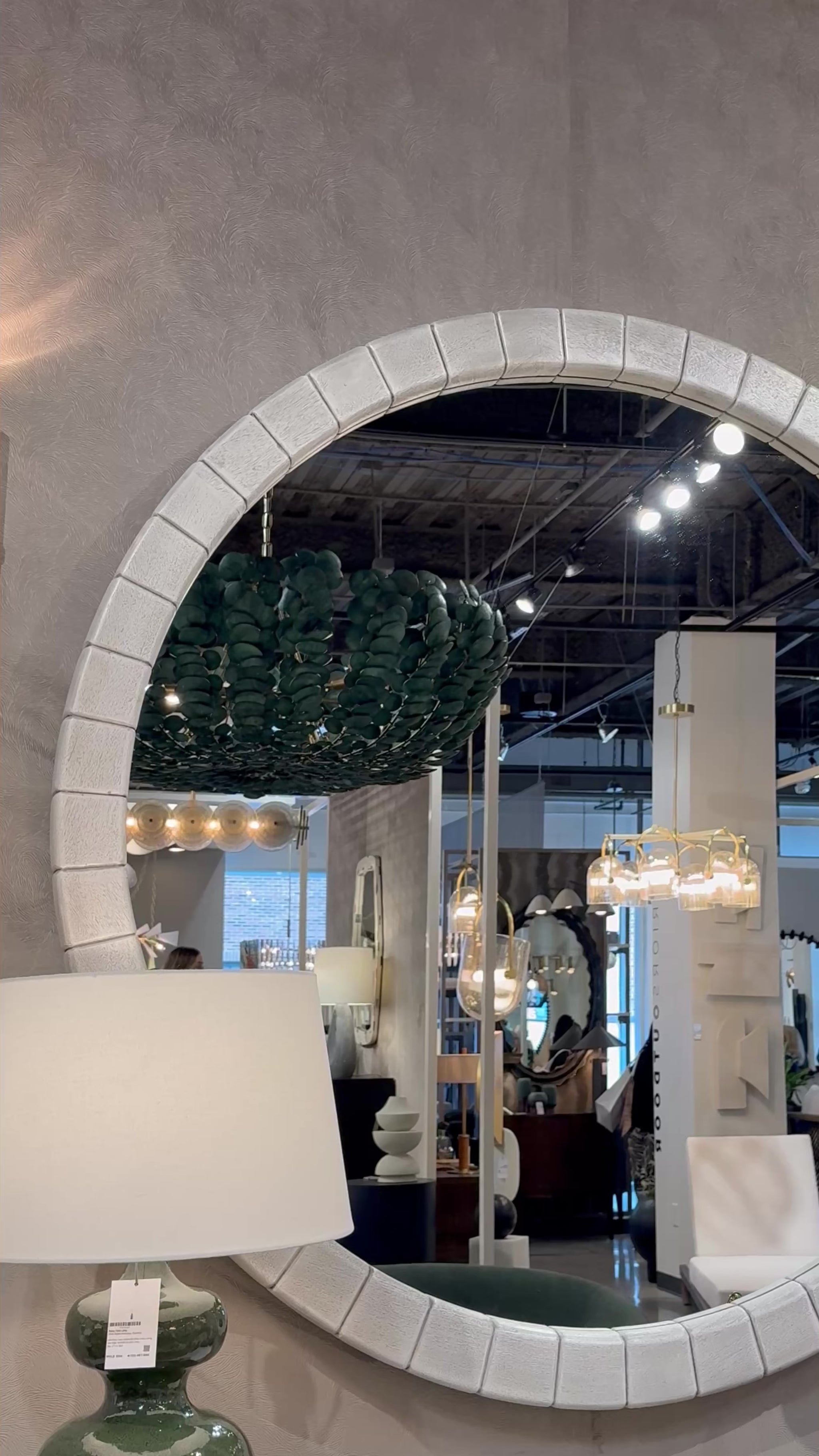 gray large round mango wood mirror in a showroom