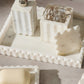 White marble jewelry display with various items on a gray surface