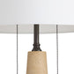 Close-up of a pendant light with a concrete base and black pull chain on a white background