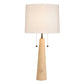 A table lamp with a tapered beige stone base, a white fabric drum shade, and a brass pull chain with small round beads.