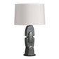 Table lamp with textured base and white shade on a white background