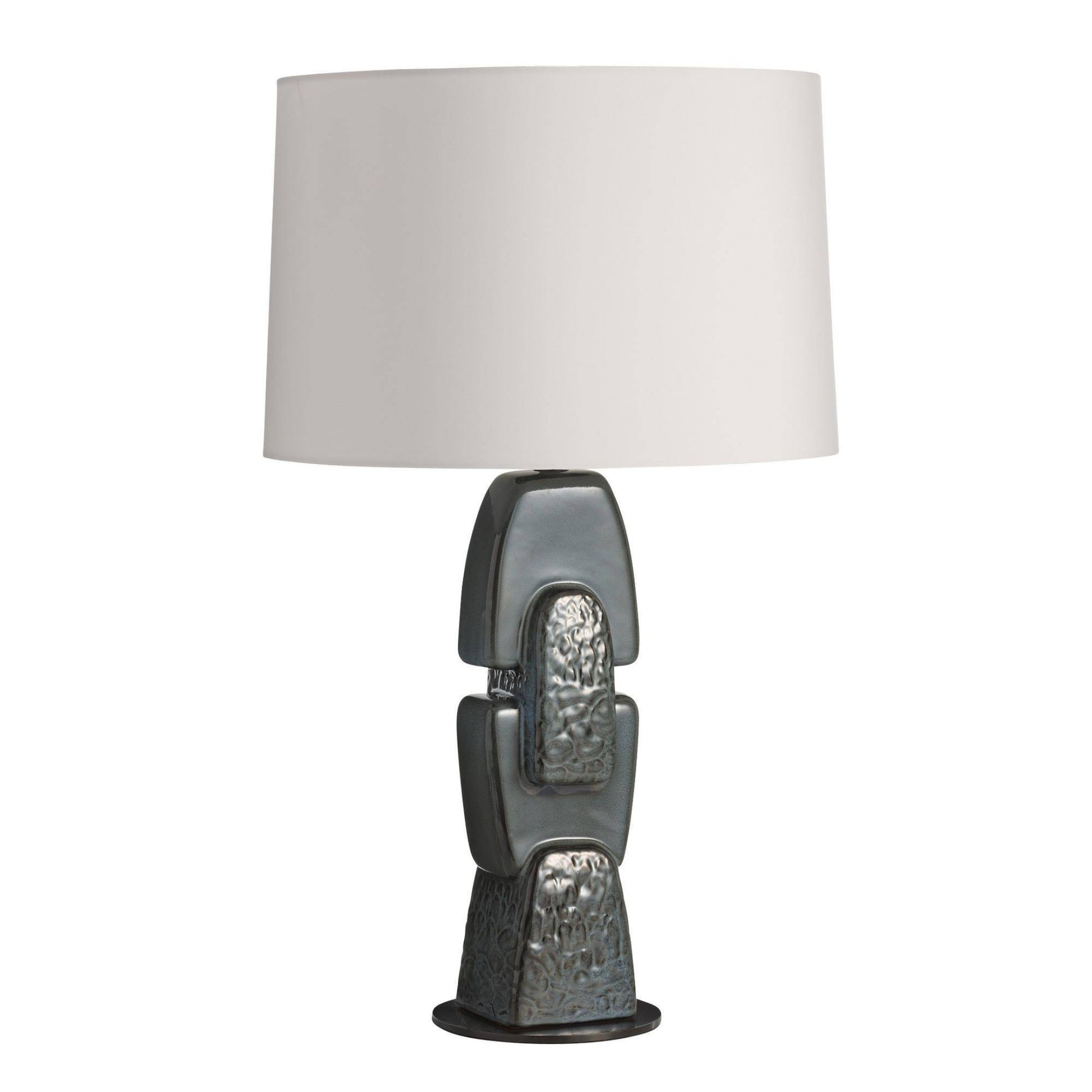 Table lamp with textured base and white shade on a white background