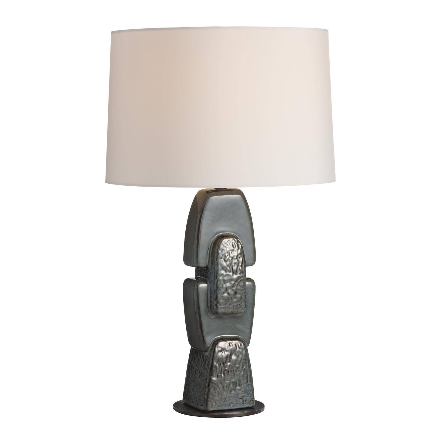 Table lamp with textured base and white shade on a white background