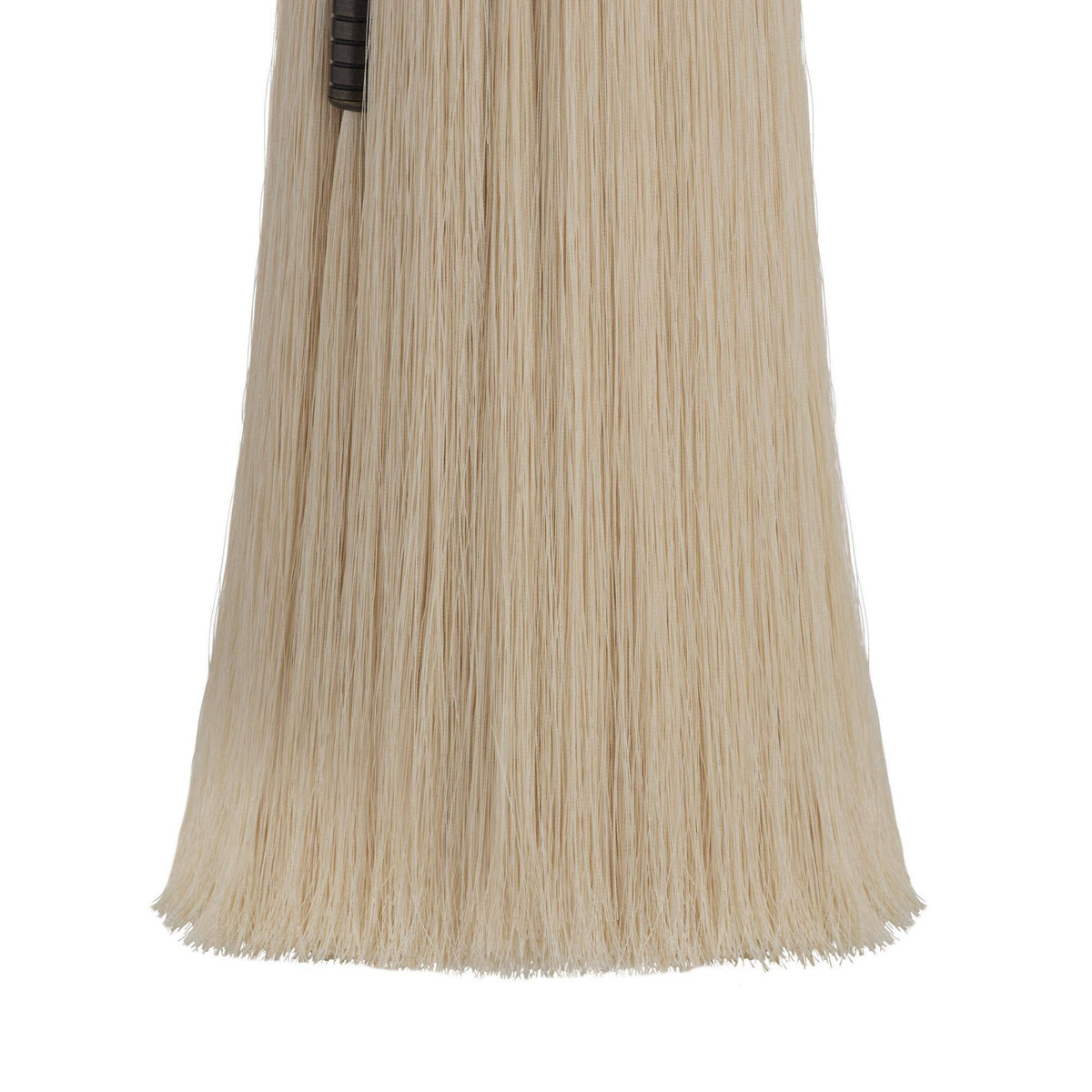 Close-up of a ivory table lamp with fringe on a white background