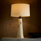 Table lamp with a unique base design on a wooden surface.