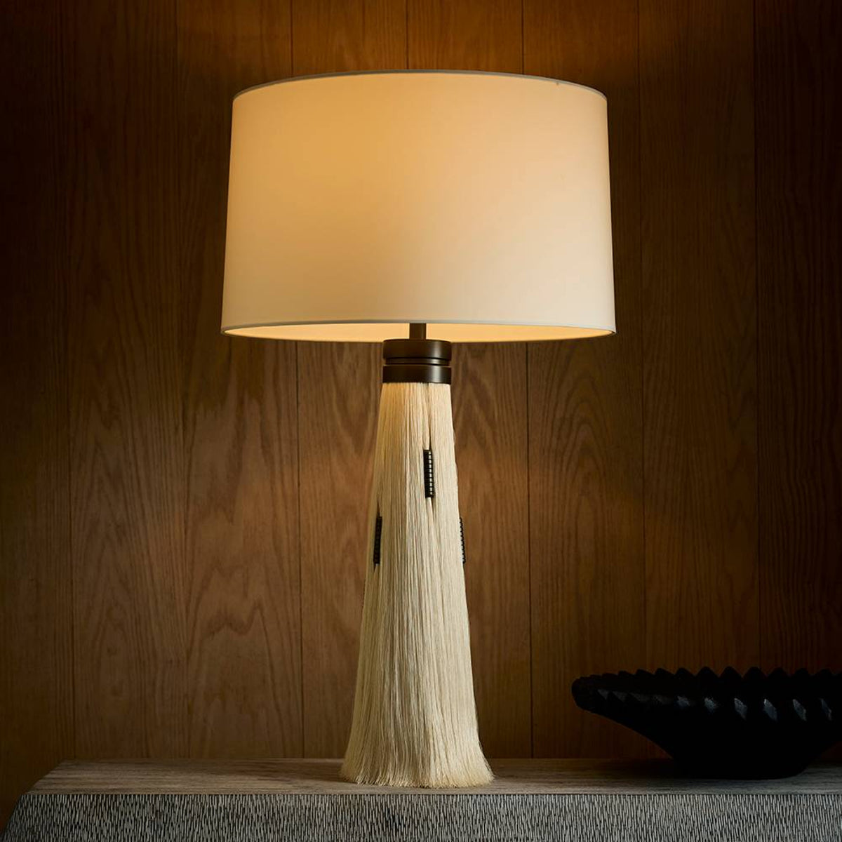 Table lamp with a unique base design on a wooden surface.