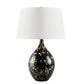 Table lamp with black base featuring gold speckles and white shade on a white background