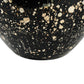 Black ceramic vase with white speckles on a white background