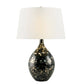 Decorative table lamp with black base and white shade on a white background