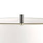 Close-up of a modern lamp shade with a white fabric body, a clear glass top, and a hammered silver metal finial on a brass rod, set against a plain white background.