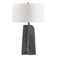 Table lamp with a textured gray base and white shade on a white background