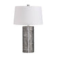 Table lamp with a textured gray base and white shade on a white background