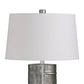Table lamp with a white shade and metallic base on a white background