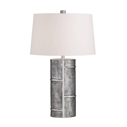Table lamp with a textured gray base and white shade on a white background