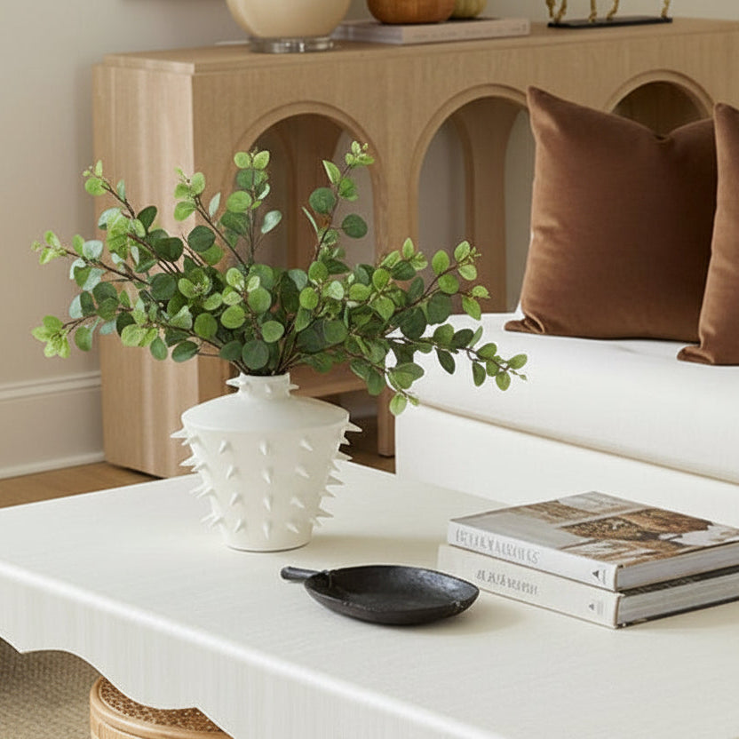 Living room with a white sofa, coffee table, and decorative items.