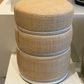 Textured cylindrical stool on a white platform with a neutral background
