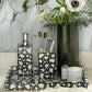 Bathroom setting with decorative soap dispenser, toothbrush holder, and floral arrangement.