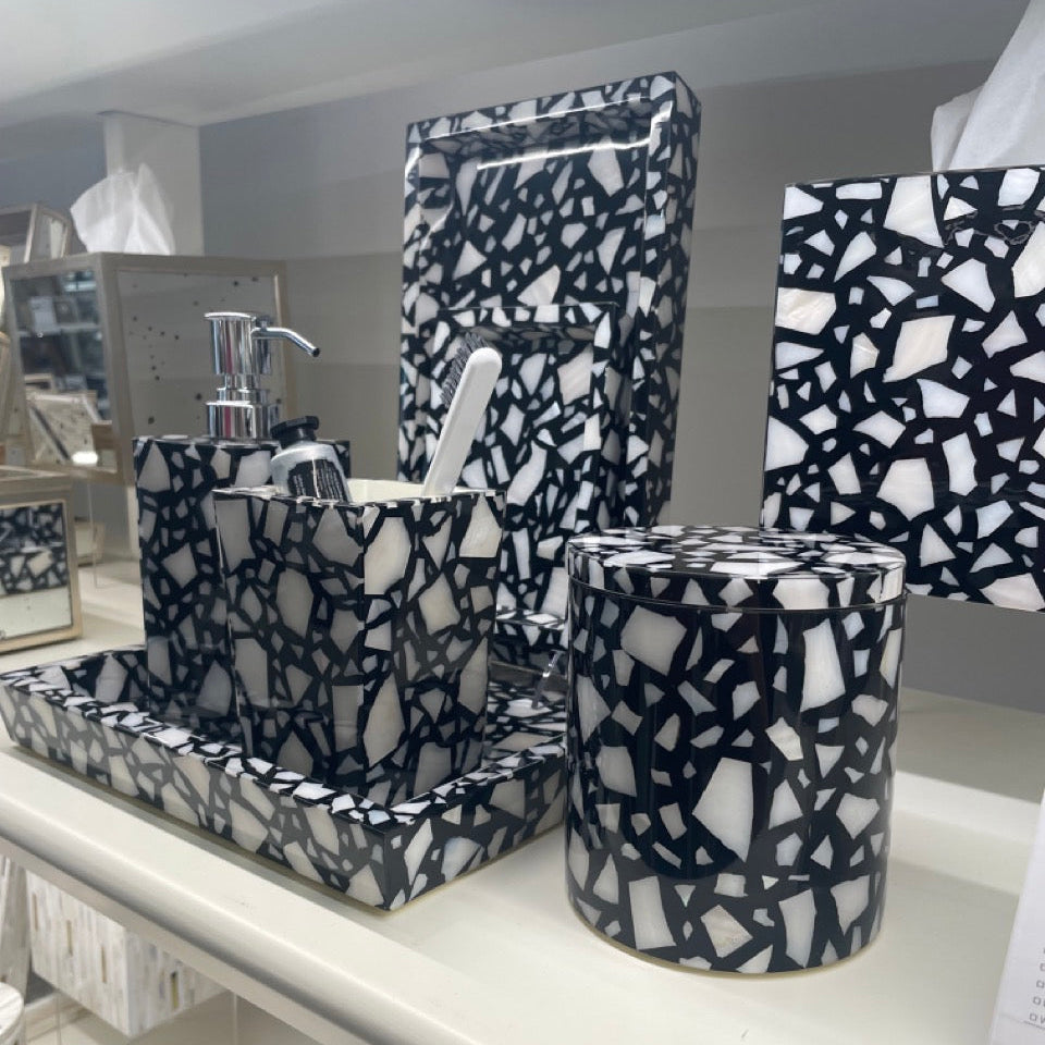 Bathroom accessories with black and white pattern on a shelf