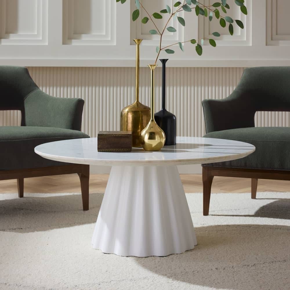 Modern living room with a white round table and decorative vases.