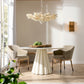 Modern dining room with a white table, chairs, and a chandelier.