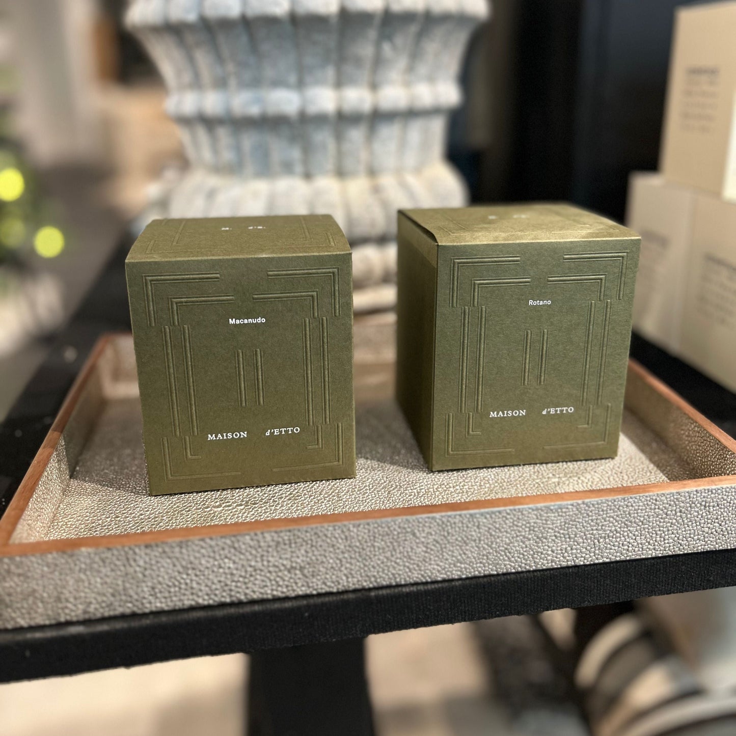 Two green boxes on a textured surface with a blurred background