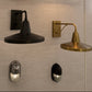 Four industrial-style wall sconces mounted on a light beige textured wall, including two black and two brass/gold models, some with adjustable arms and one with a rectangular frame.