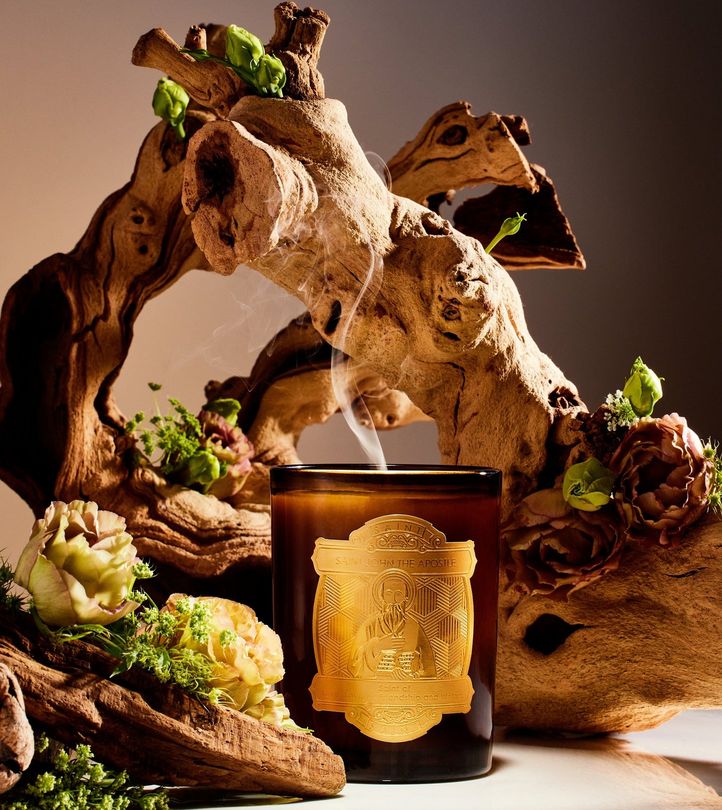 Candle with decorative wooden arch and plants on a dark background