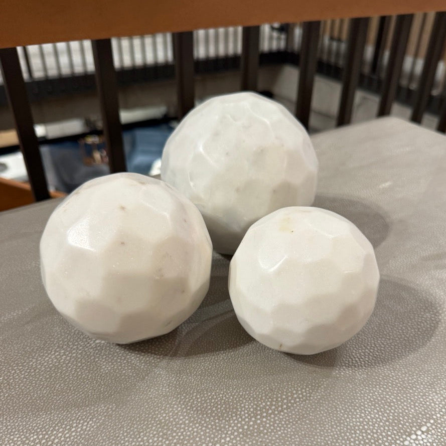 Three white golf balls on a textured surface with a blurred background