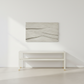 Abstract wall art piece on a white wall above a white console table.