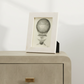 Framed illustration of a hot air balloon on a beige surface with a white background