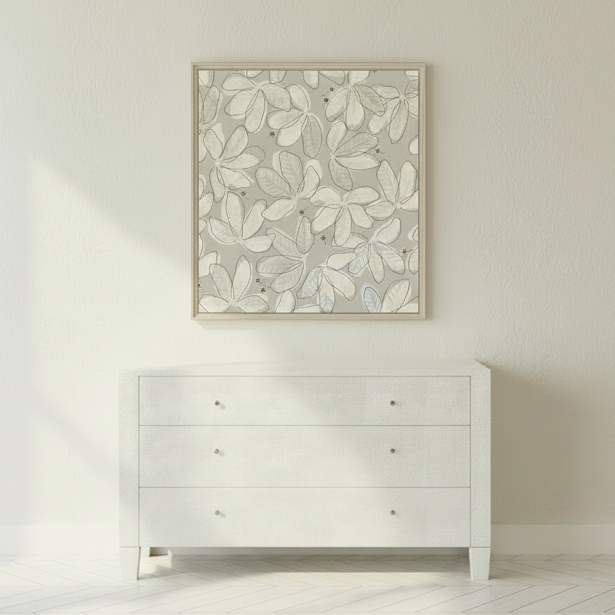 A square framed wall art print with a light gray and white leaf pattern, displayed above a white three-drawer dresser against a white wall on a light herringbone floor.