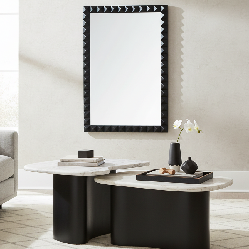 Modern living room with a black and white coffee table, mirror, and sofa.