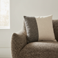 Brown textured sofa with two pillows in a neutral setting
