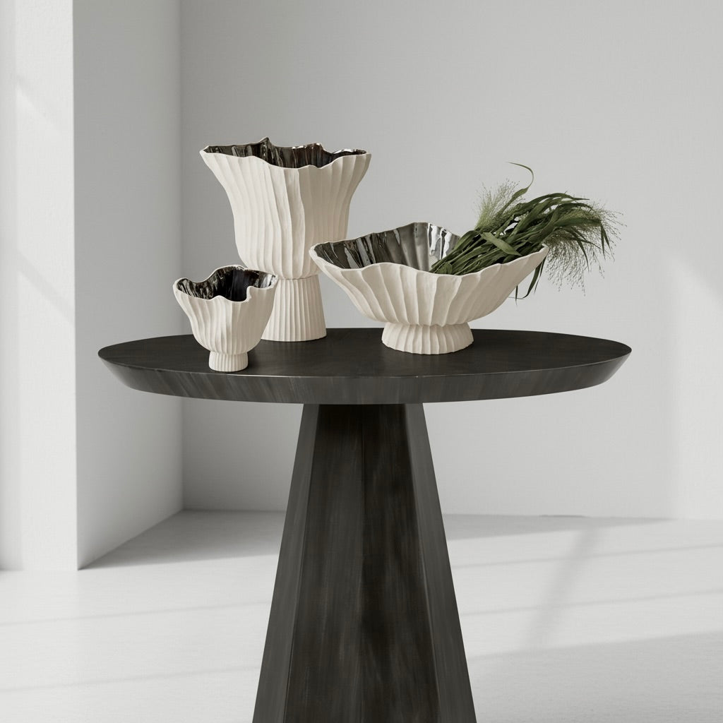 Set of three decorative vases on a black round table against a light gray wall. (demetrius)