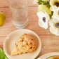 Bouquet of white flowers with a scone on a wooden table