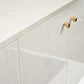 Close-up of a white kitchen cabinet with gold handles
