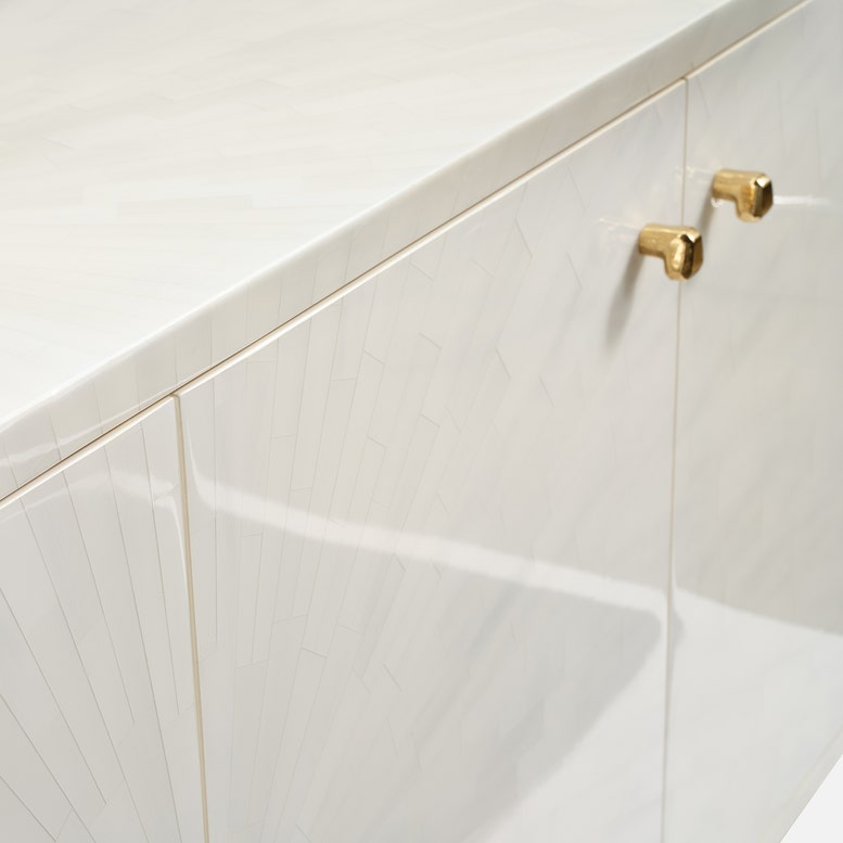 Close-up of a white kitchen cabinet with gold handles