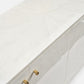 Close-up of a white cabinet with gold knobs on a white background