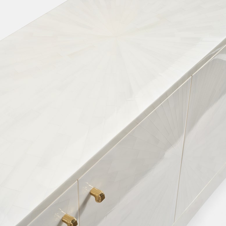 Close-up of a white cabinet with gold knobs on a white background