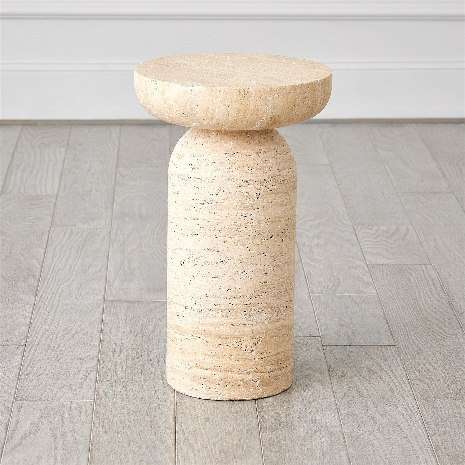 Beige stone side table on a wooden floor with a neutral background