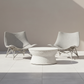 Two white wicker chairs and a matching table on a tiled floor.