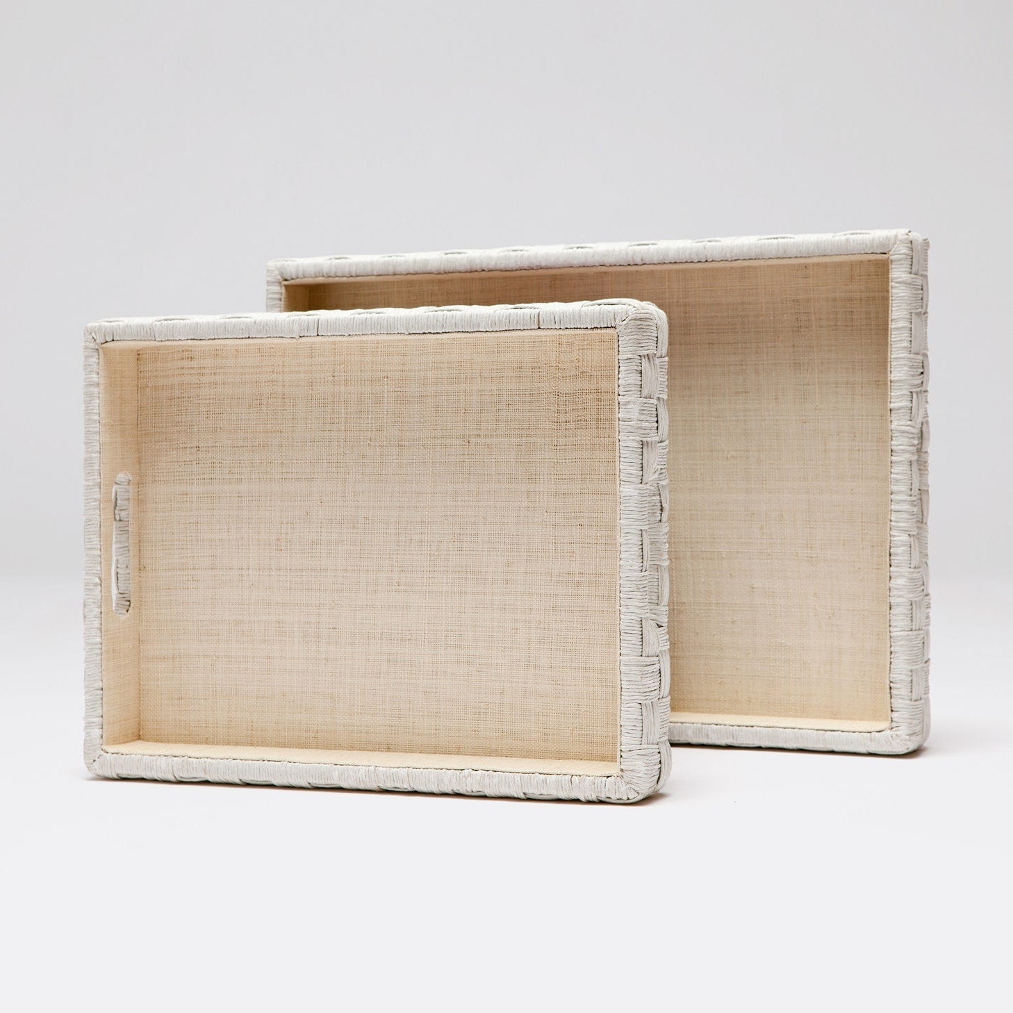Two woven trays with white frames on a light gray background