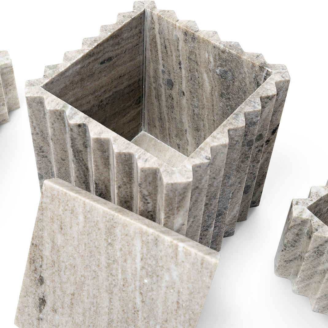 Decorative stone planter with geometric design on a white background