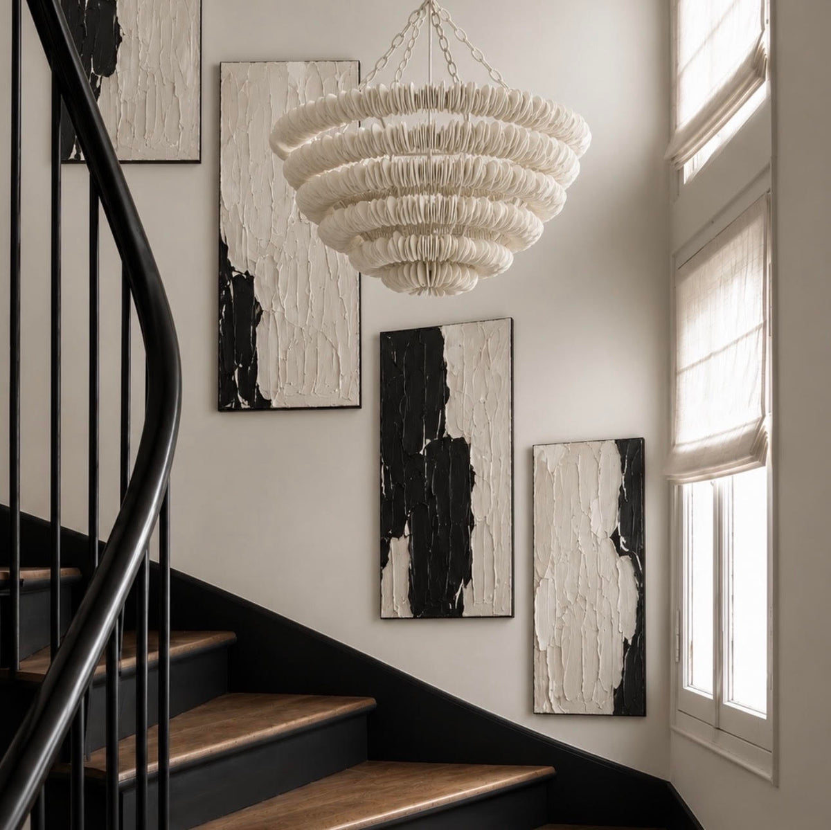 staircase showing a white wood cut disc chandelier