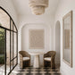Modern interior with a round table and chairs on a checkered floor, framed by architectural elements.