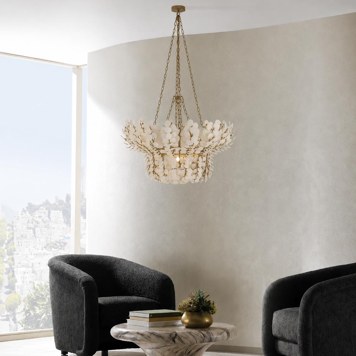 Modern living room with a chandelier, armchairs, and a coffee table.