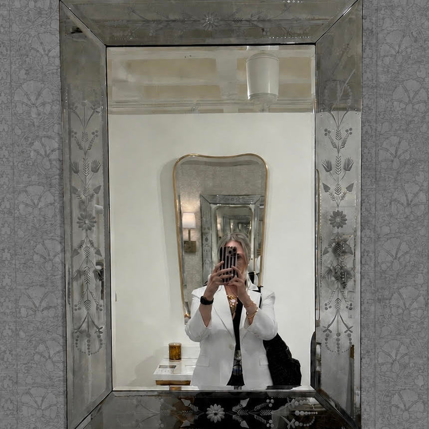 Decorative mirror with floral patterns on a textured wall