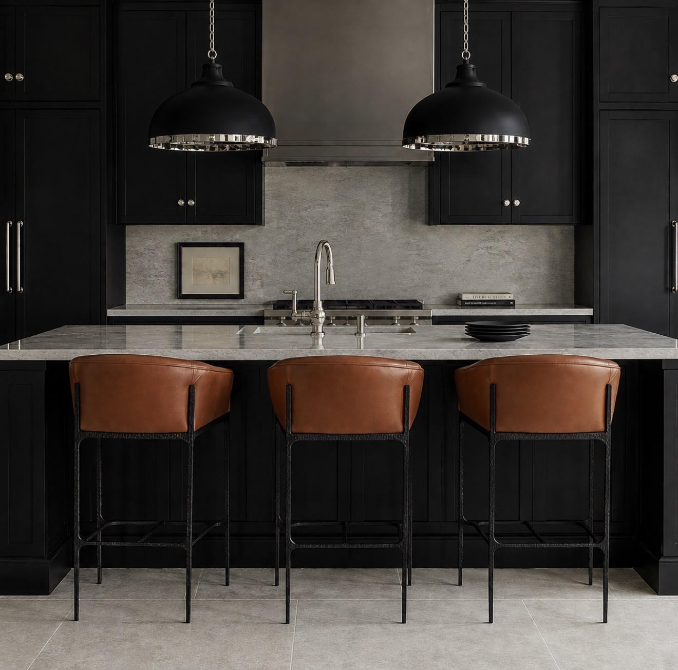 A modern kitchen island with a gray stone countertop, black cabinetry, two black pendant lights, and three brown leather bar stools with black metal frames.