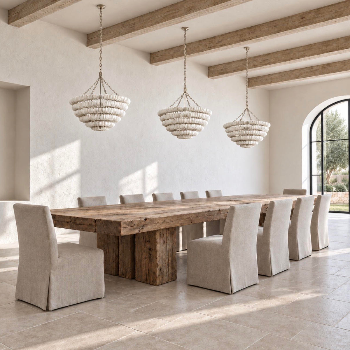 A rustic dining room scene featuring a long wooden dining table surrounded by upholstered chairs, with three woven pendant lights hanging from exposed wooden ceiling beams.