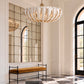Kaia Chandelier in ivory coconut shell suspended in an elegant entryway with arched black-framed windows, paneled white walls, a large grid mirror, and a velvet bench.
